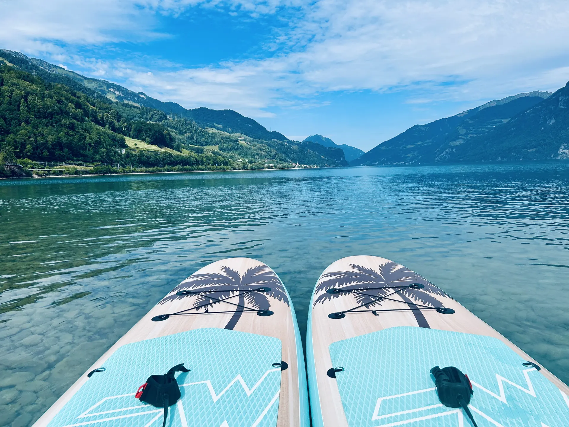 Blick vom Wasser: zwei Boardspitzen nebeneinander auf dem glasklaren See